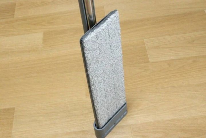 木目調の床に立てかけられたグレーの簡単水絞り3段モップ