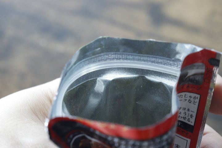 手で持たれた「PattoDELI 燻製塩こしょう」のチャック付き袋の開口部