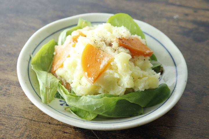 レタスと人参が添えられたポテトサラダに燻製塩こしょうがかけられている