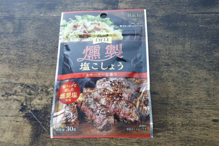 「PattoDELI 燻製塩こしょう」のパッケージを木目調の台に置いた俯瞰写真