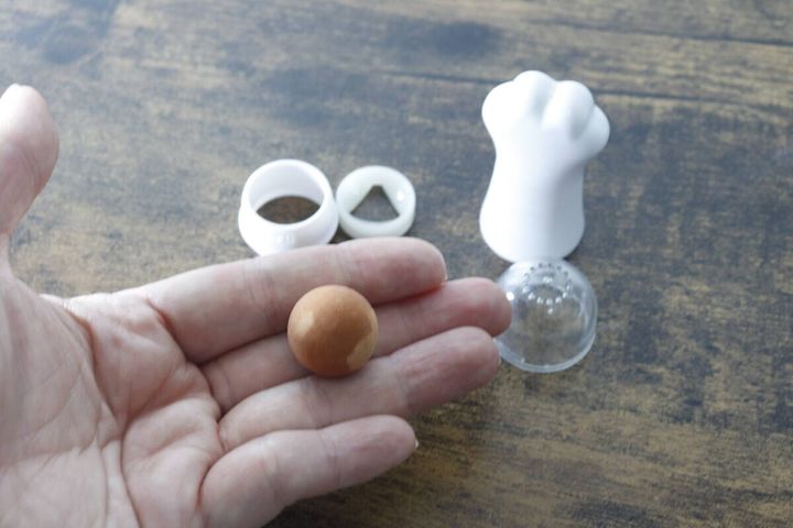 分解されたあぶらとりボールの部品と手のひらに乗ったボール