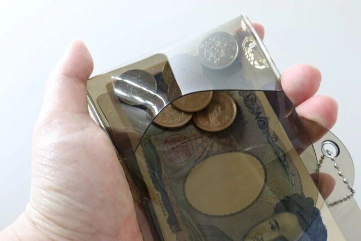 クリアな三つ折り財布を開きお札と小銭が見える