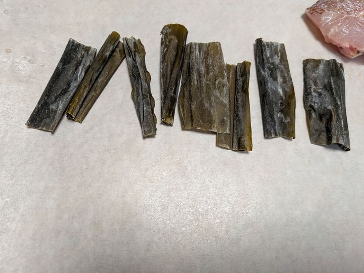 1、クッキングシートを大きめに切り、昆布（あれば）を並べる。