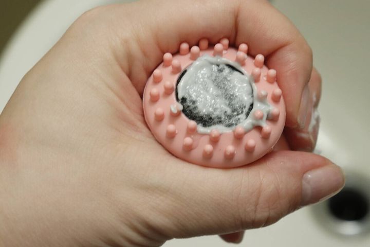 洗顔ブラシの底面に白い洗顔料が塗布され、泡立てる前の状態