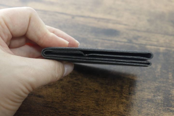 指で挟んで薄さを示す折りたたみスマホスタンド