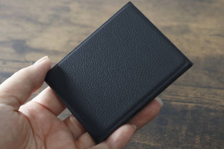 手のひらに乗せた黒い折りたたみスマホスタンド