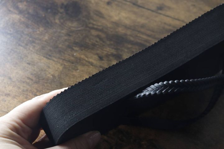手で持った黒い厚底ビーチサンダルの分厚いソール部分を横から撮影