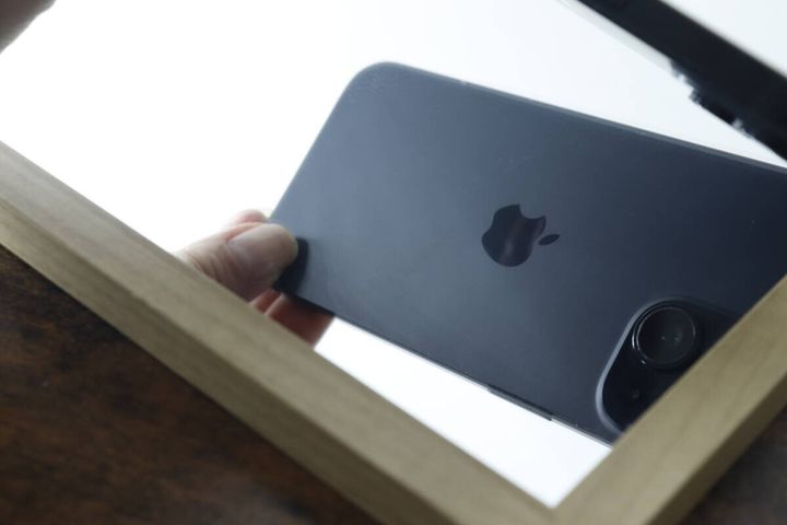拭き取られてきれいになった鏡に映るスマートフォン