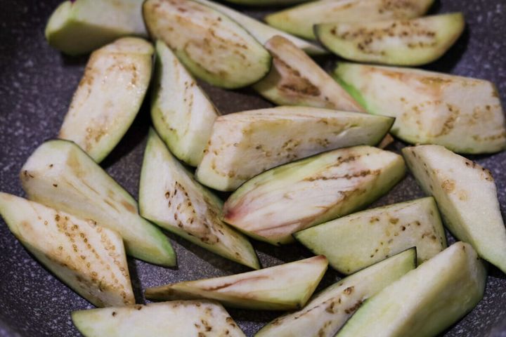フライパンでなすの皮目を下にして焼いている調理工程