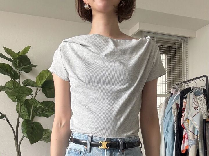 女性がグレーのドレープネックTを肩を出さずに着用