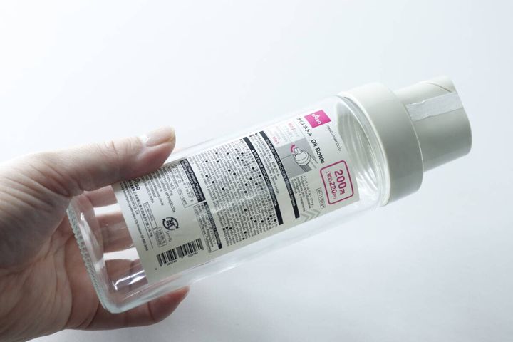 手で持ったダイソーのオイルボトル、商品ラベルが貼られた状態