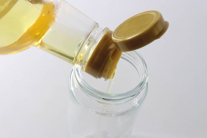 オイルボトルに市販の食用油を注ぎ入れている様子