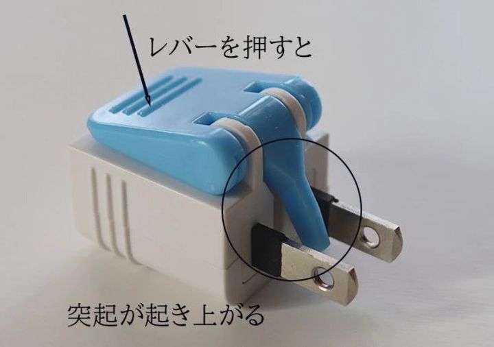 青い電源アダプターのレバーを押すと突起が起き上がる様子