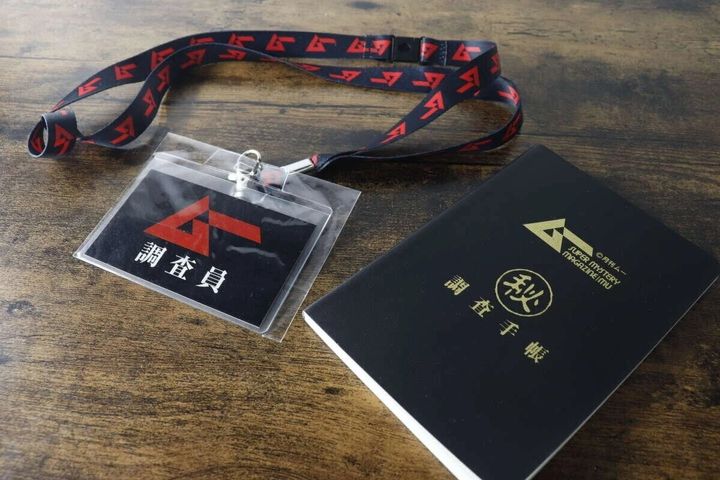 『ムー』のロゴが入ったネックストラップ付きカードケースと黒いA6ノート