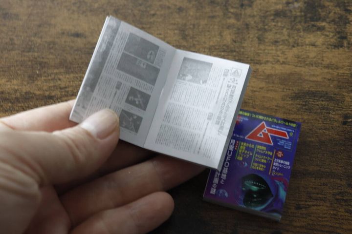 手のひらで開かれた『ムー ミニブックノート』のページと、隣に置かれた閉じたノート