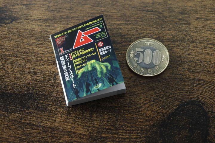 黒い表紙の『ムー ミニブックノート』と500円玉を並べてサイズを比較