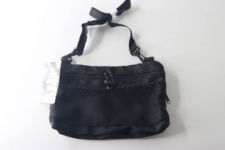 黒いショルダーバッグが白い背景に置かれている