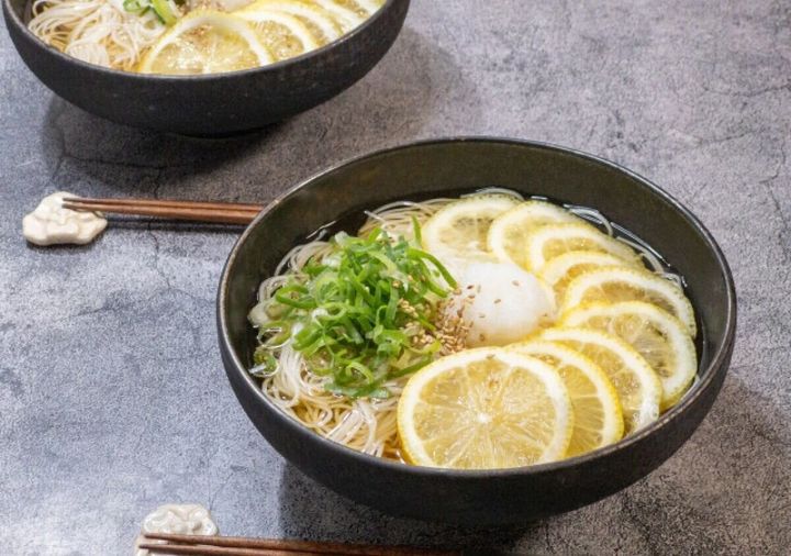 黒い器にレモンとねぎが乗った冷やしそうめん