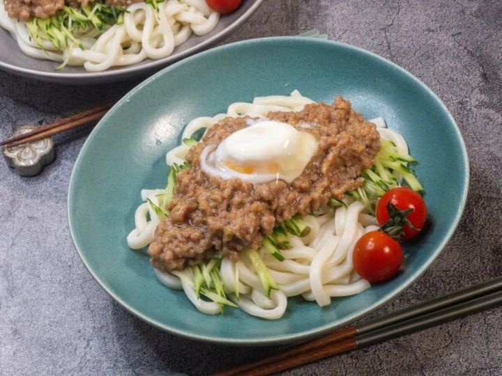 水色の器に豚そぼろと温泉卵が乗った冷やしうどん
