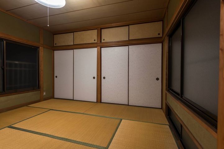 左右に窓があり、正面に襖と天袋が並ぶ広い和室。