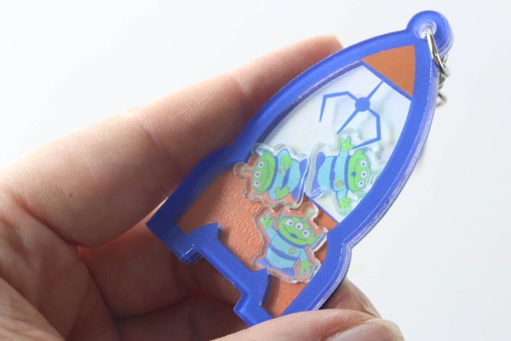 手に持ったエイリアンのキーホルダーを振っている様子