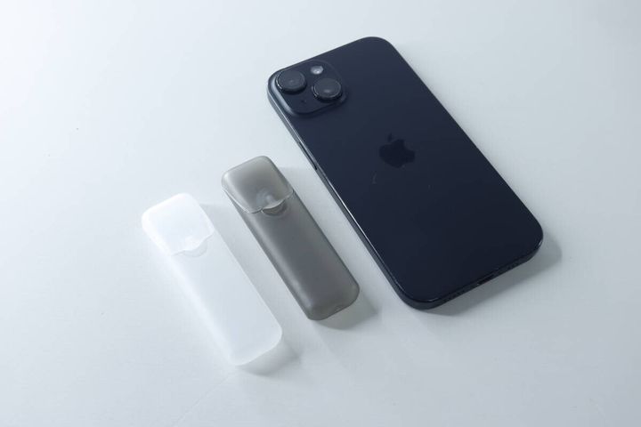 スマートフォンと並べられた白とグレーのトラベル小物ケース2個