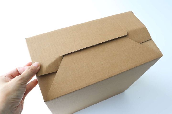 女性の手が段ボールダストボックス本体を組み立てている様子