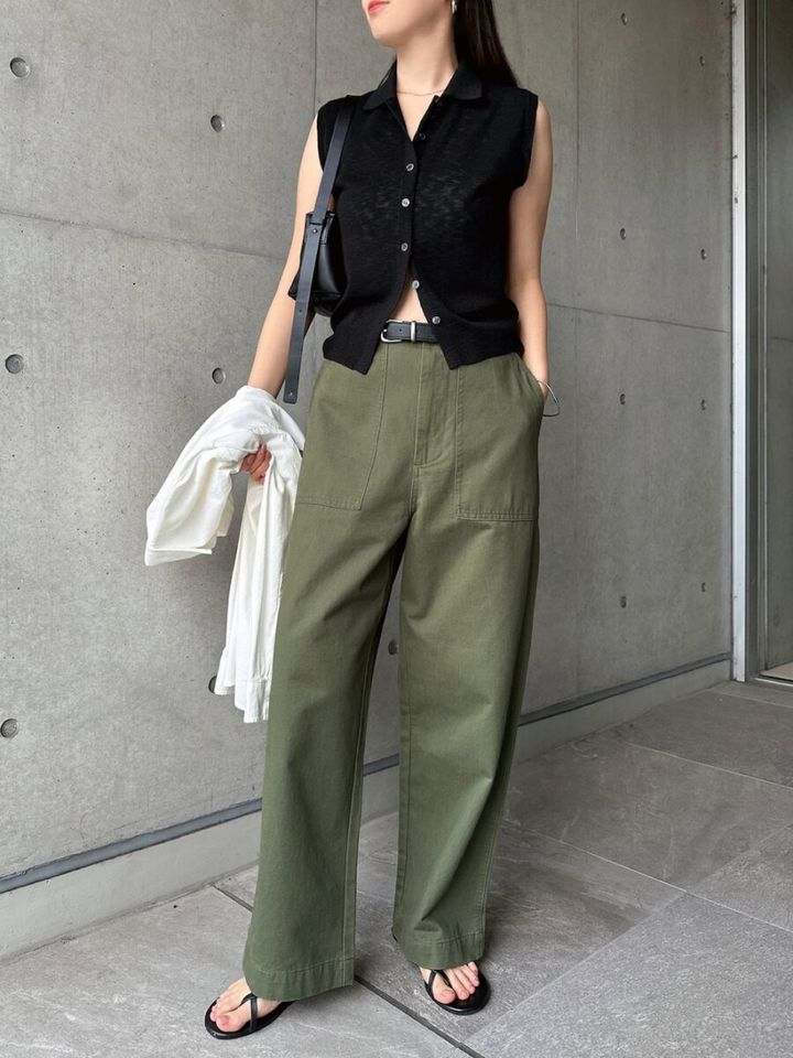 透け感黒ニットとカーキワイドパンツ、黒バッグを持った女性
