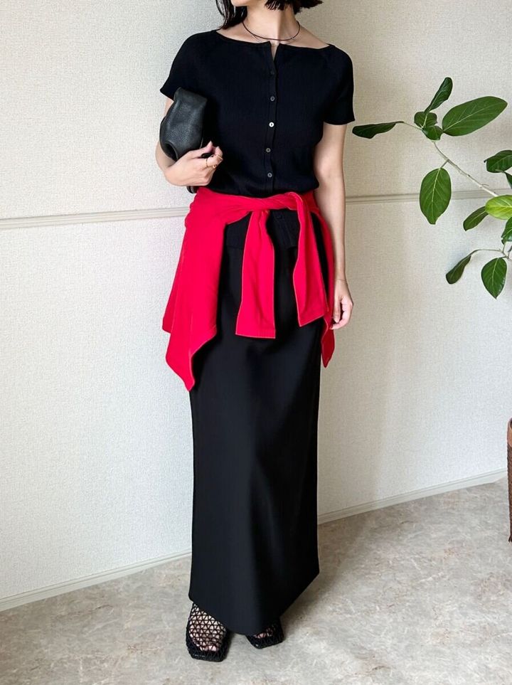 黒カーデと黒スカートに赤いカーデを腰巻きした女性