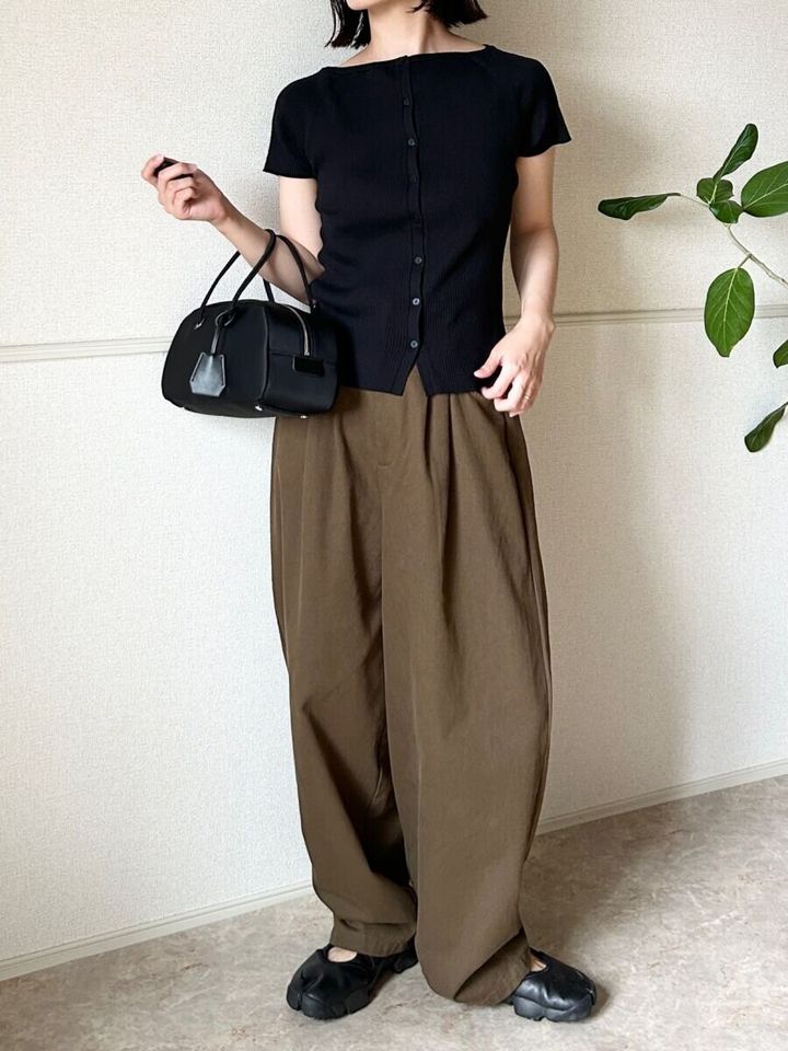 黒カーデとワイドパンツ、黒スニーカーの女性