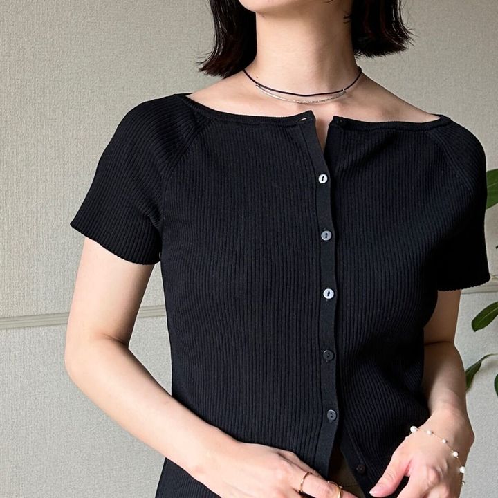黒カーデのボタンを少し開けた女性の胸元アップ
