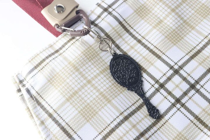 チェック柄のバッグにアンティーク風ミラーキーホルダーを付けている