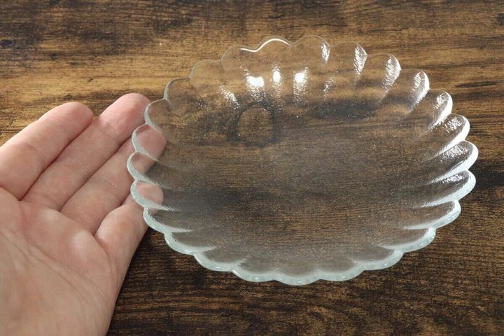 手のひらに乗せた透明な波模様のガラス皿
