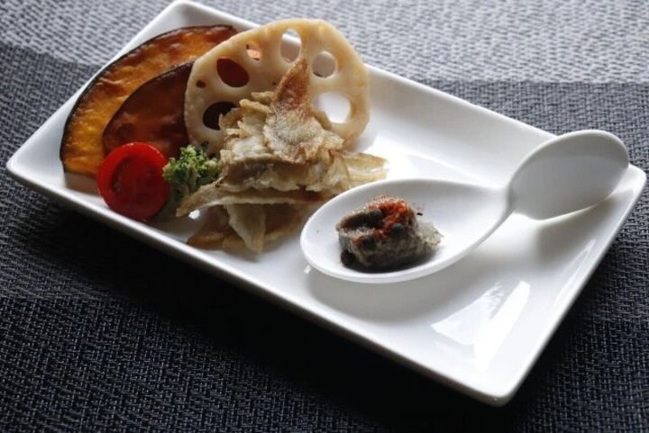 白い長皿に盛り付けられた前菜とアミューズスプーンに乗った一品
