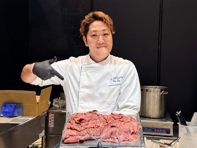 シェフが鹿肉のトレイを持つ様子を写した写真