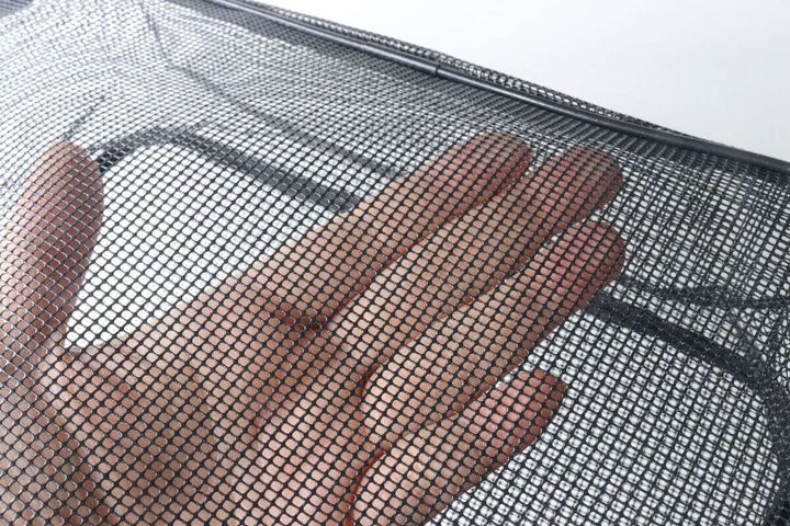 スパバッグのメッシュ素材を指で押さえ、通気性を確認している手元