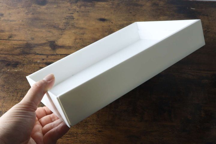 白いダイソーキッチン伸縮ケースを片手で持っている様子