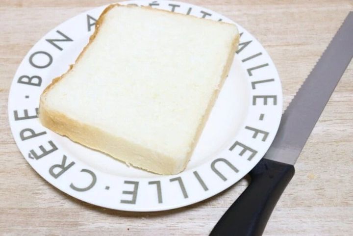 白い皿に乗った食パンと、その横に置かれたパンスライサー