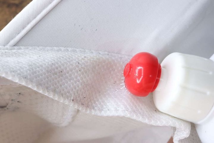 帽子の内側の黄ばんだ部分に洗剤の先端を当てて塗布している