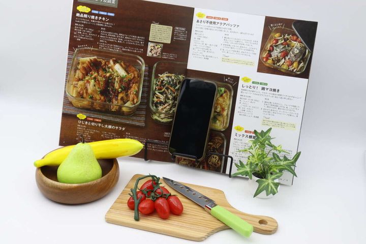 レシピ本とスマートフォンがブックスタンドに立てられ、手前に調理器具の模型が置かれている