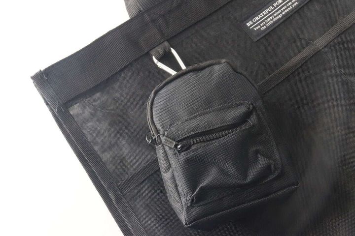 黒いバッグにミニリュックキーホルダーを付けている様子