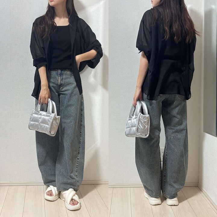 黒いシアーシャツとバレルジーンズを着用した女性