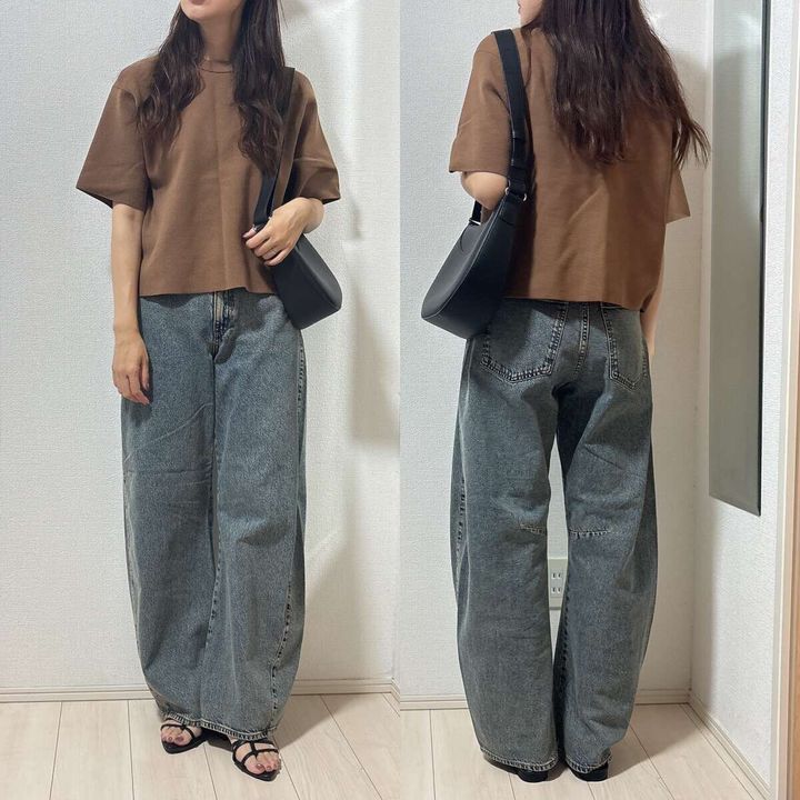 茶色のニットTとバレルジーンズを着用した女性