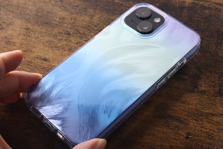 iPhoneに装着された流沙色ケースを手に持っている