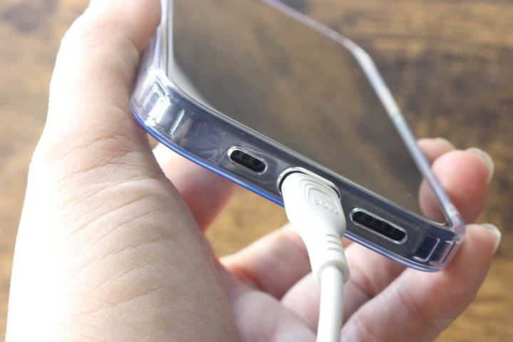ケースを装着したiPhoneに充電ケーブルを接続している