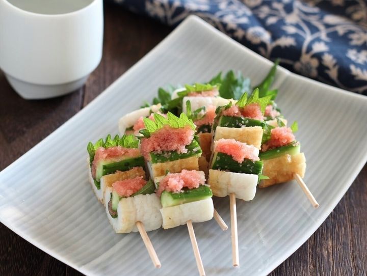 ちくわにきゅうりとしそを詰め明太子をのせた串料理が白い皿に盛られている