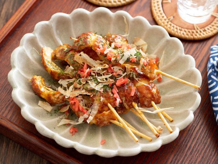 マヨソースちくわ串にお好み焼きのように紅ショウガと鰹節がトッピングされている