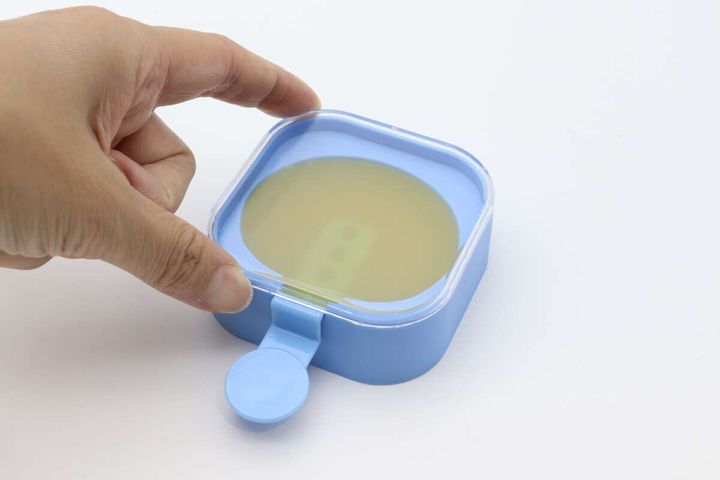 アイスキャンディーメーカーに透明な蓋を閉めている手元
