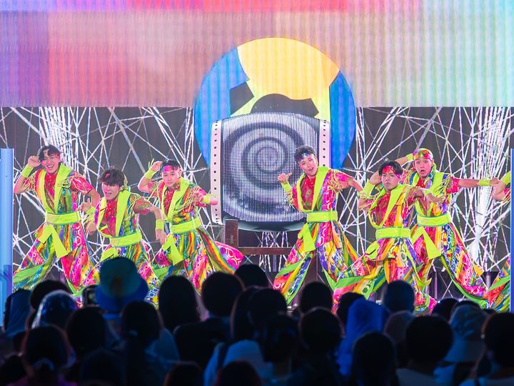 和太鼓の前で低く構えるダンサーたち