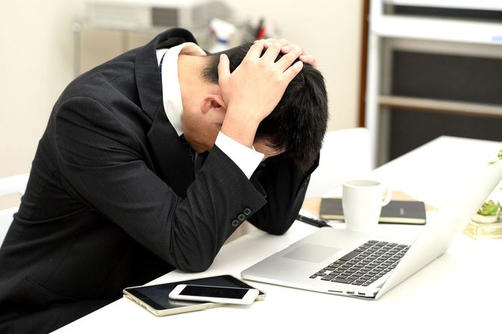 頭を抱えて嘆いている男性